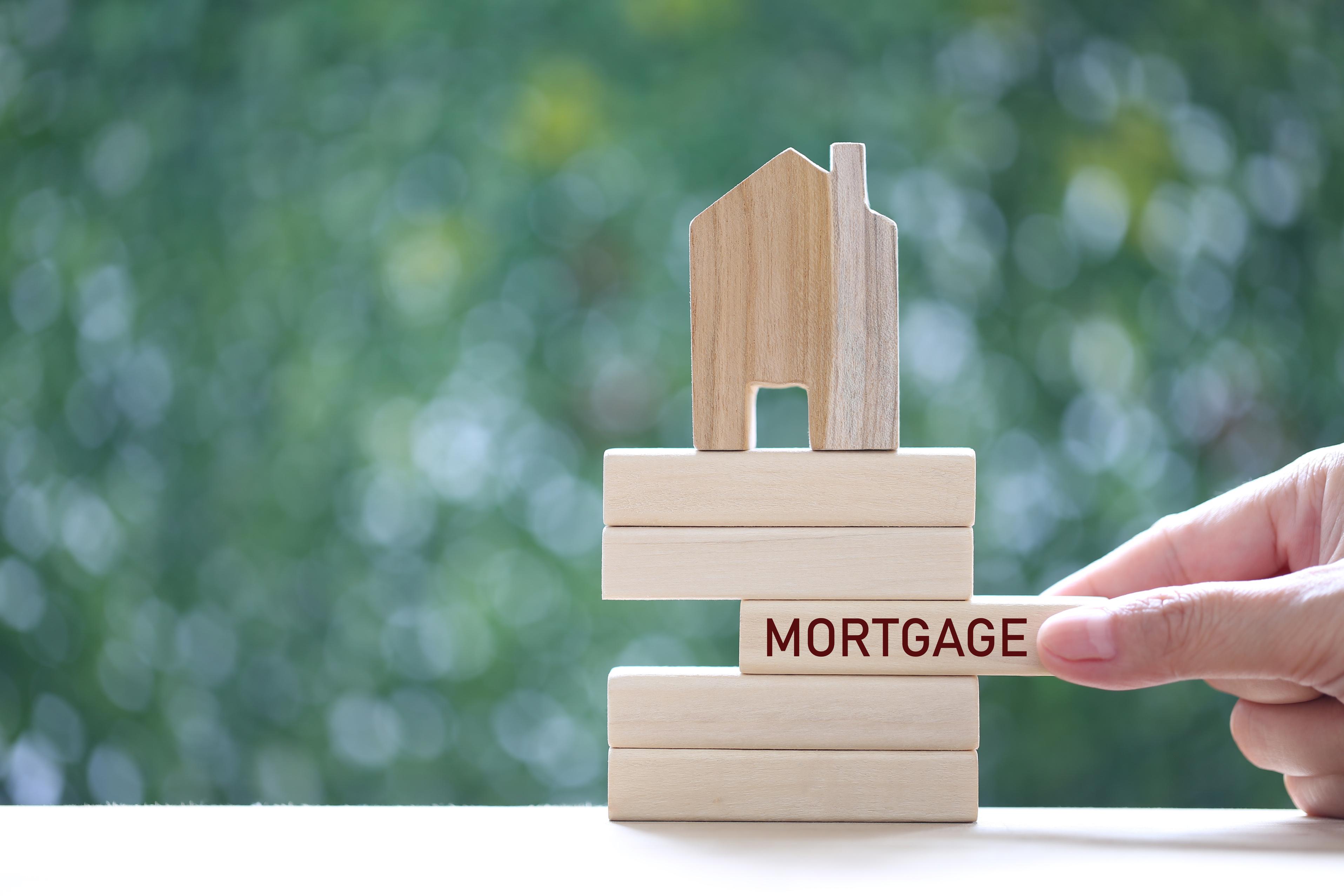 Mortgage,Model House on Wooden Block with Word "MORTGAGE" on Nat